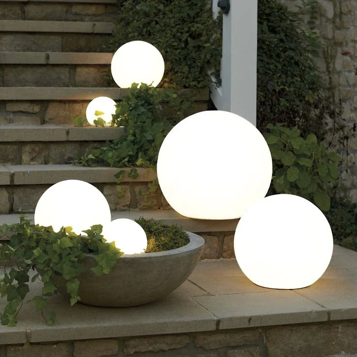 Luna Globe Garden Light in three sizes beside garden steps