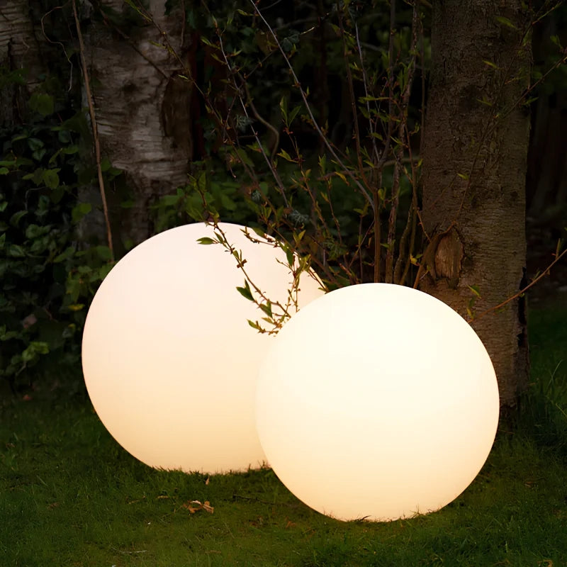 Two sizes of globe light under a tree