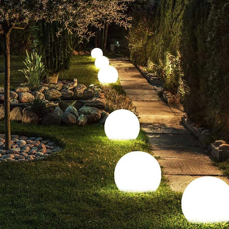 Globe lights along a lawn edge at night